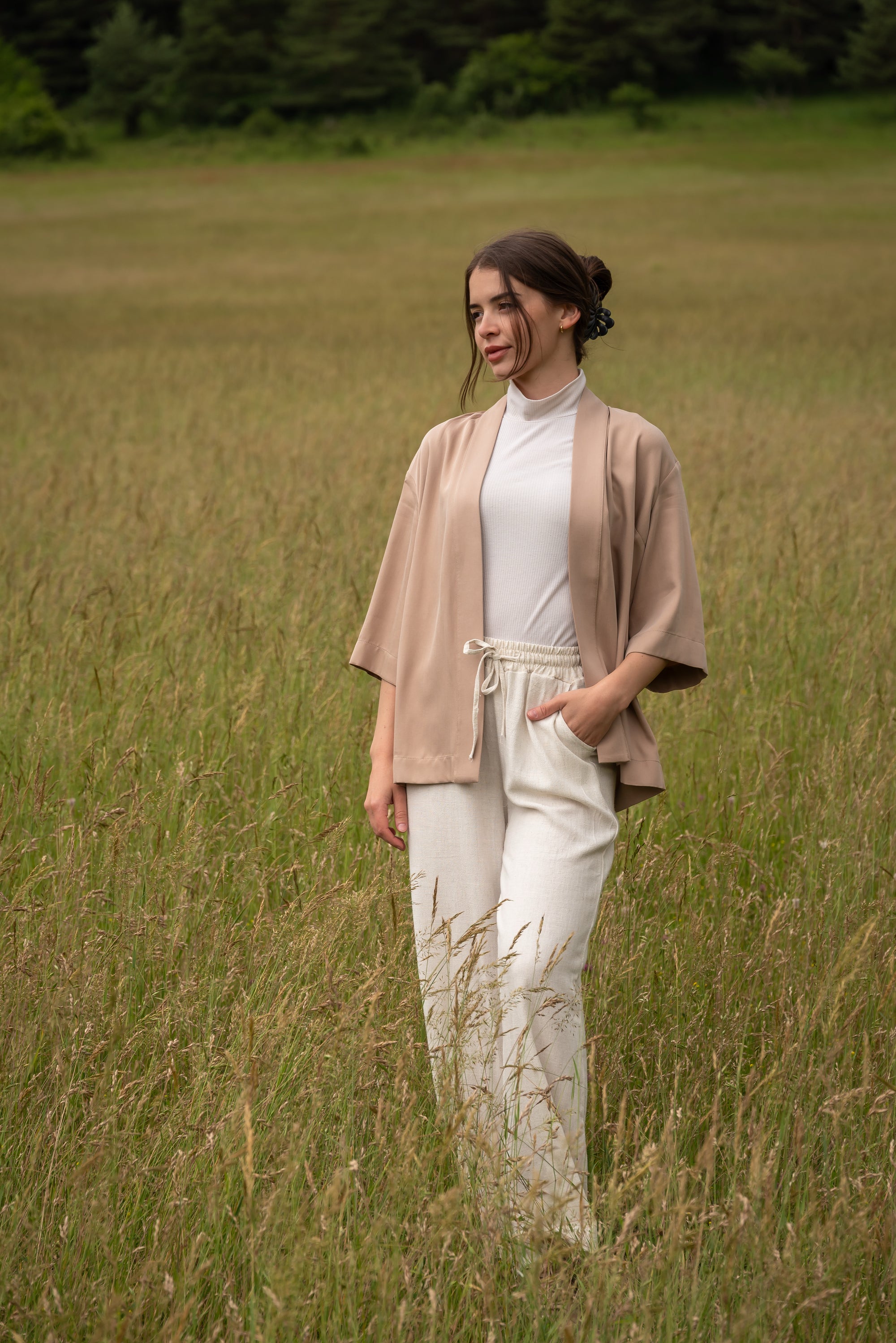 Woman wearing kimono, standing in a field.